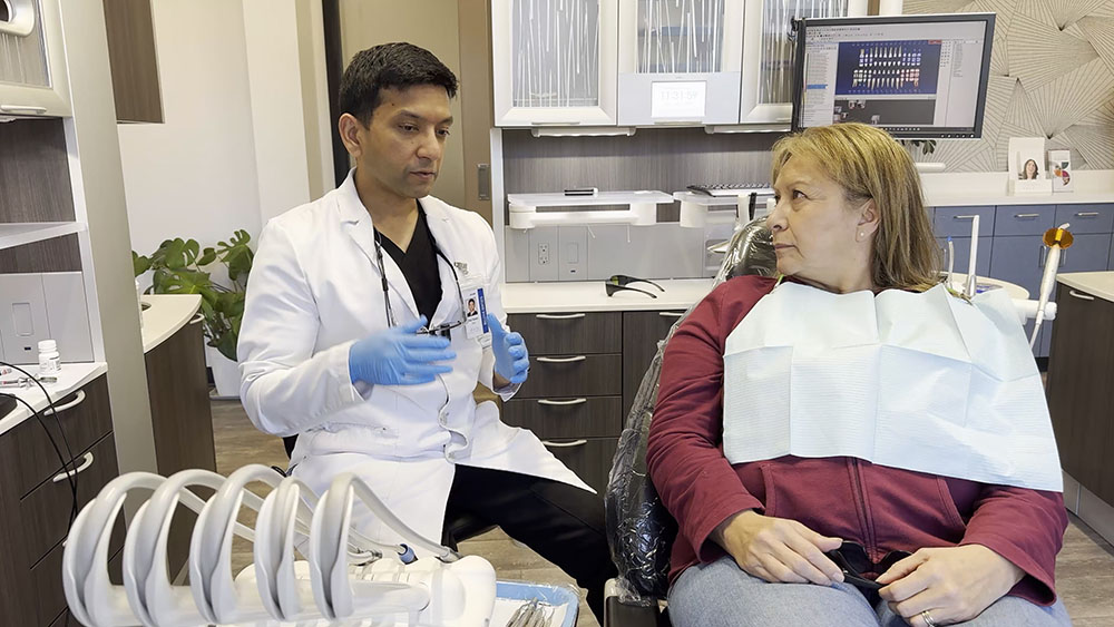 Dentist consulting with patient in dental chair about treatment options