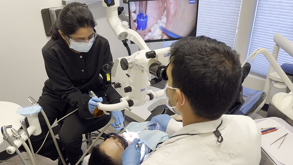 Dentist performing precise dental procedure using microscope technology