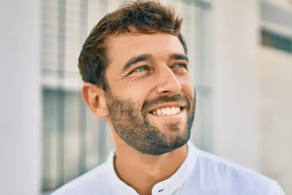 Smiling man with healthy teeth, representing successful dental treatment with sedation dentistry