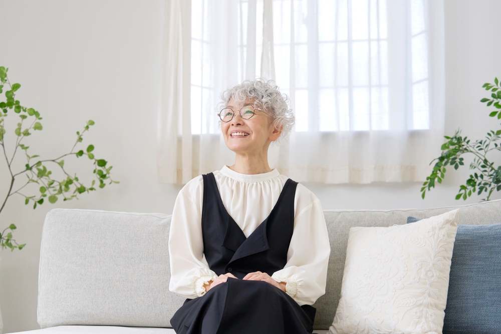 Senior woman smiling indoors after dental implants, representing healthy aging and dental wellness