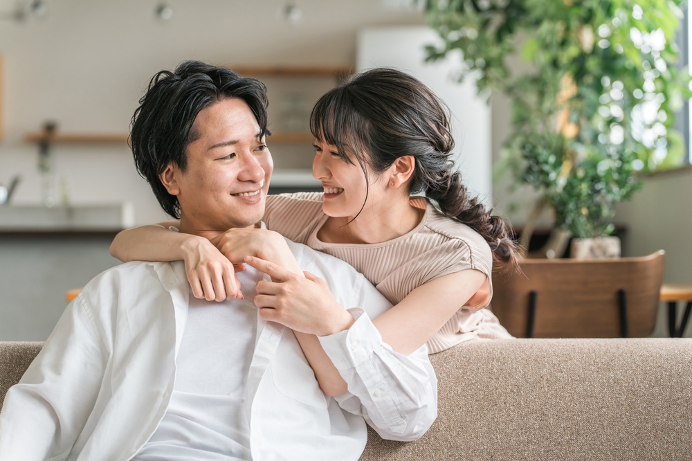 Happy couple smiling together at home, representing comfortable and confident dental care results
