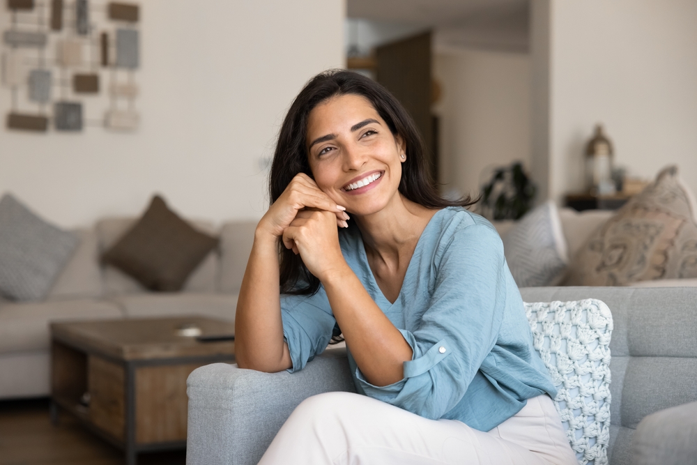 Relaxed smiling woman at home, representing comfortable and stress-free dental care