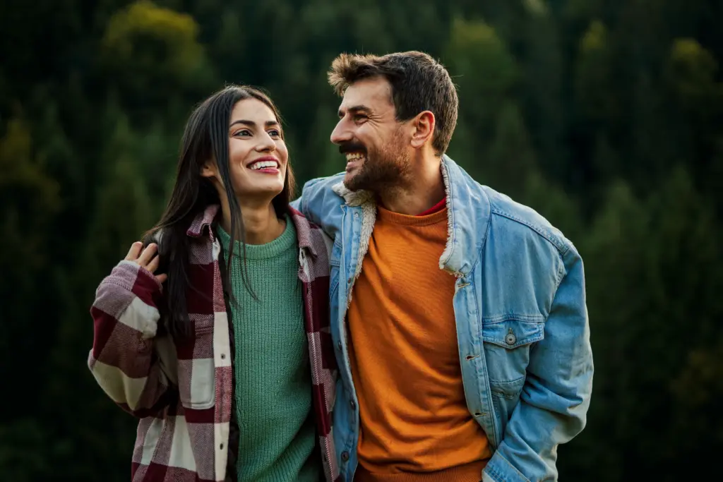 Happy couple walking outdoors, representing confident smiles and healthy dental results on Laser-Enabled Dentistry